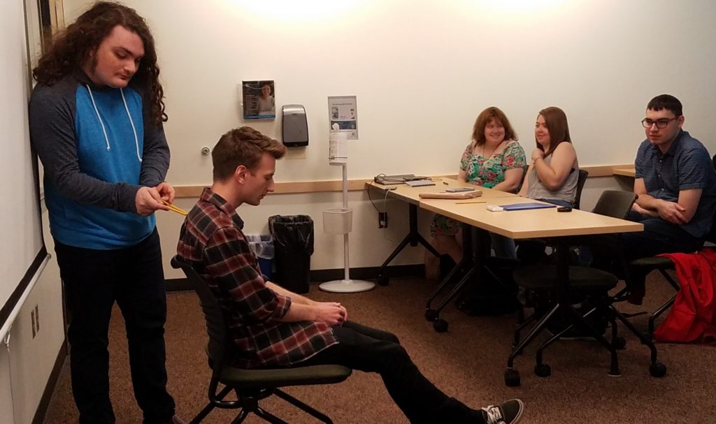 two young adults give a presentation in front of their class