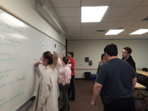 group of students work at white board in class