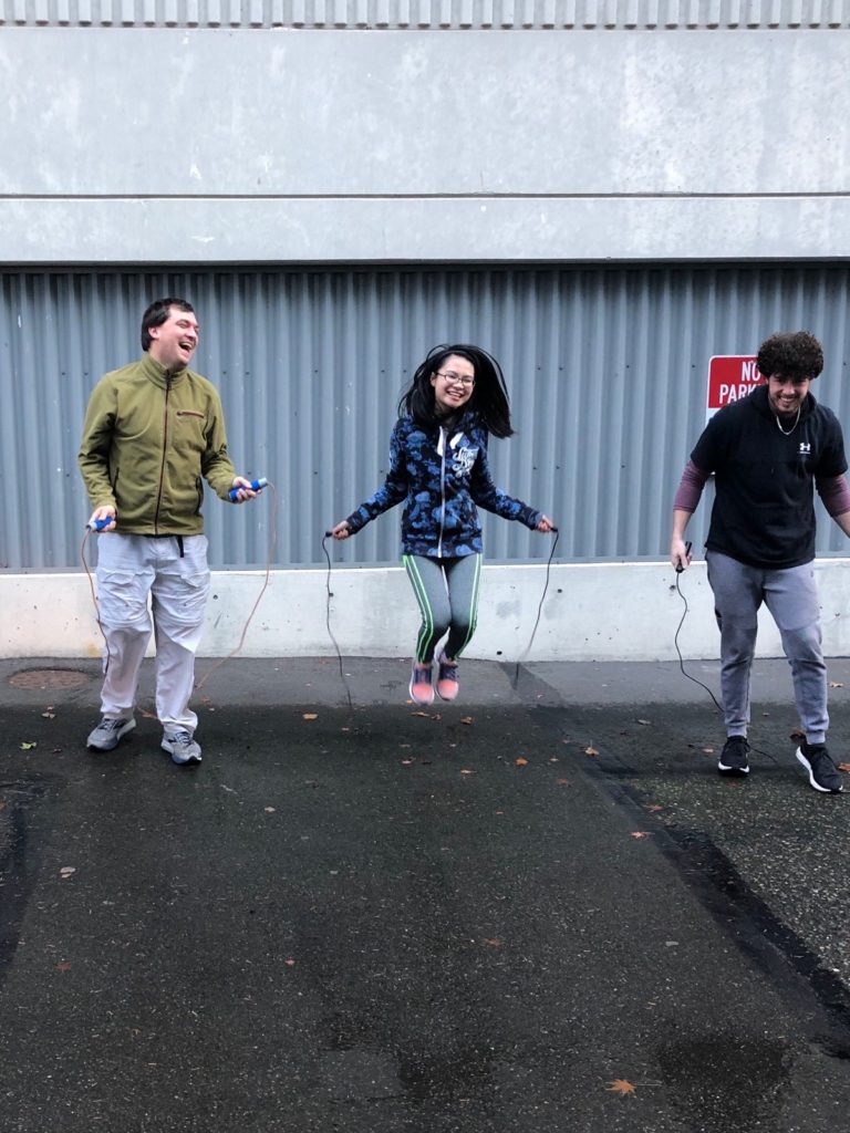 three young adult jumping rope