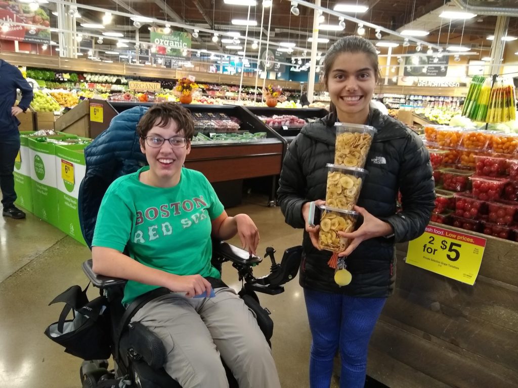 young adult and a young adult in a wheelchair shop at a grocery store