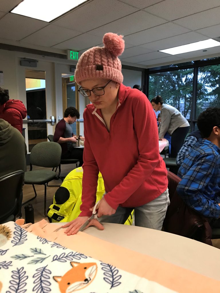 young woman cuts fabric