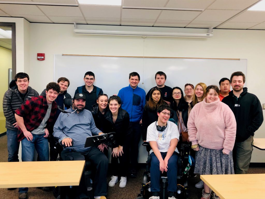 group of young men and women college students in front of a classroom