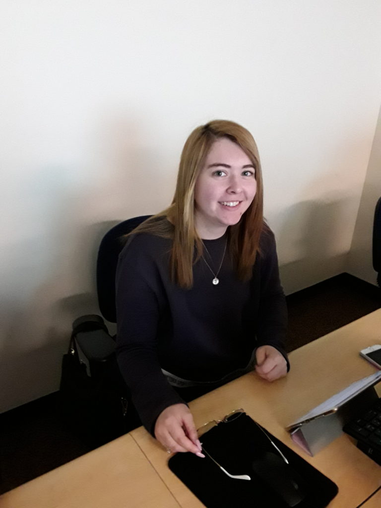 young adult woman sits at a computer