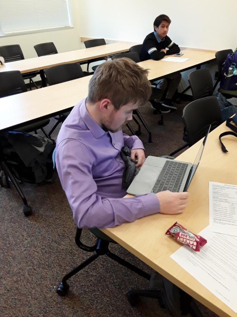 a young man prepares for a job interview on his computer