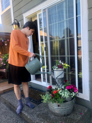 young man waters flowers