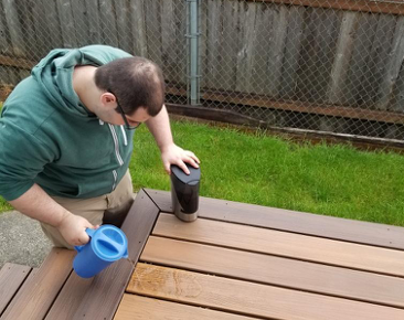 young man cleaning a picnic table