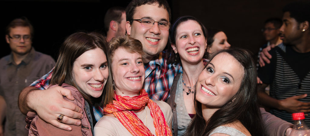 Five OLS Students embrace in a group hug at their Senior Presentation Night before graduation. 