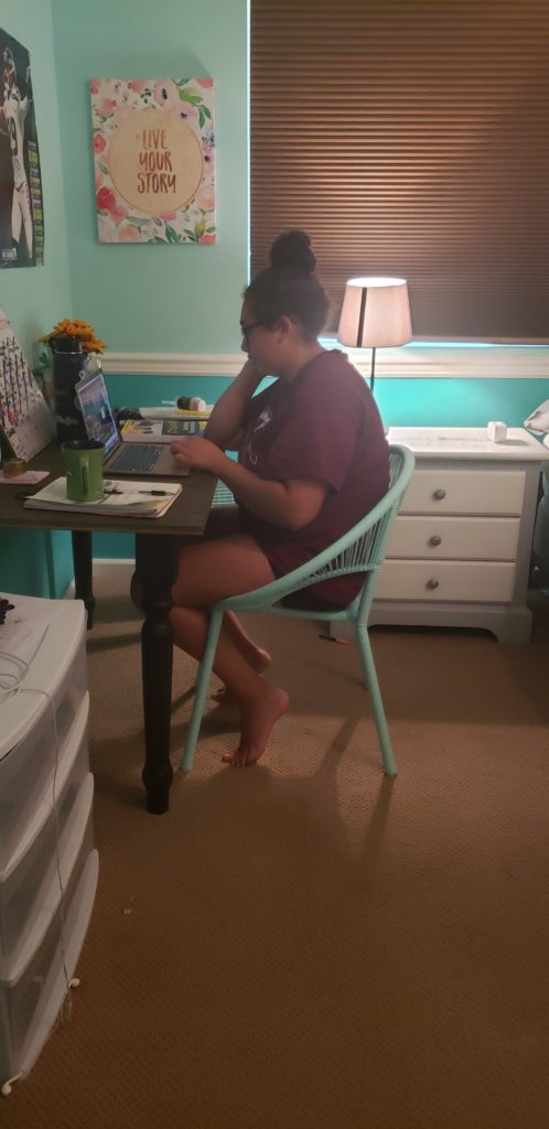 An OLS student works on her computer at her home desk 