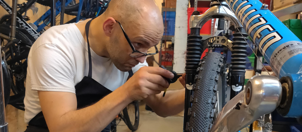 An OLS student works repairing a bike for their OLS internship