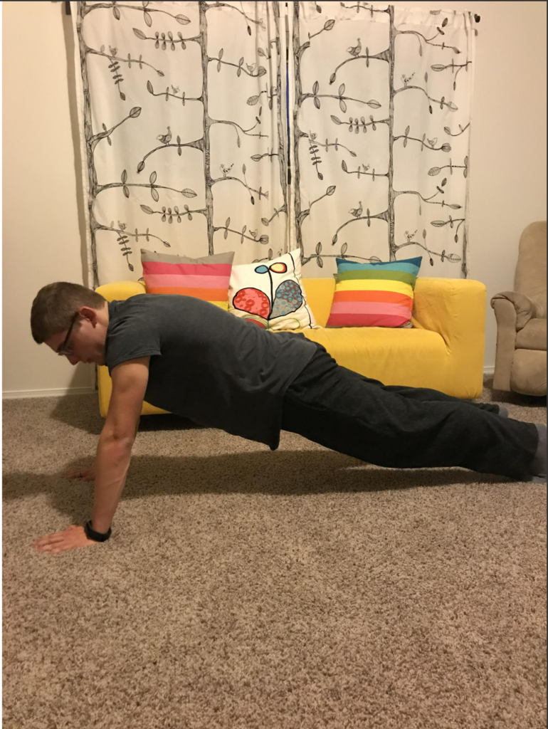 OLS student holds plank pose for yoga course