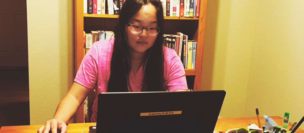 OLS Student works on a laptop at their home,