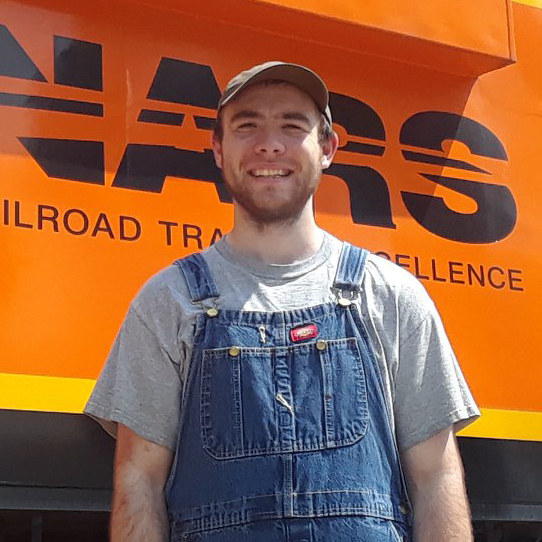 OLS Alumni smiling in front of railroad car