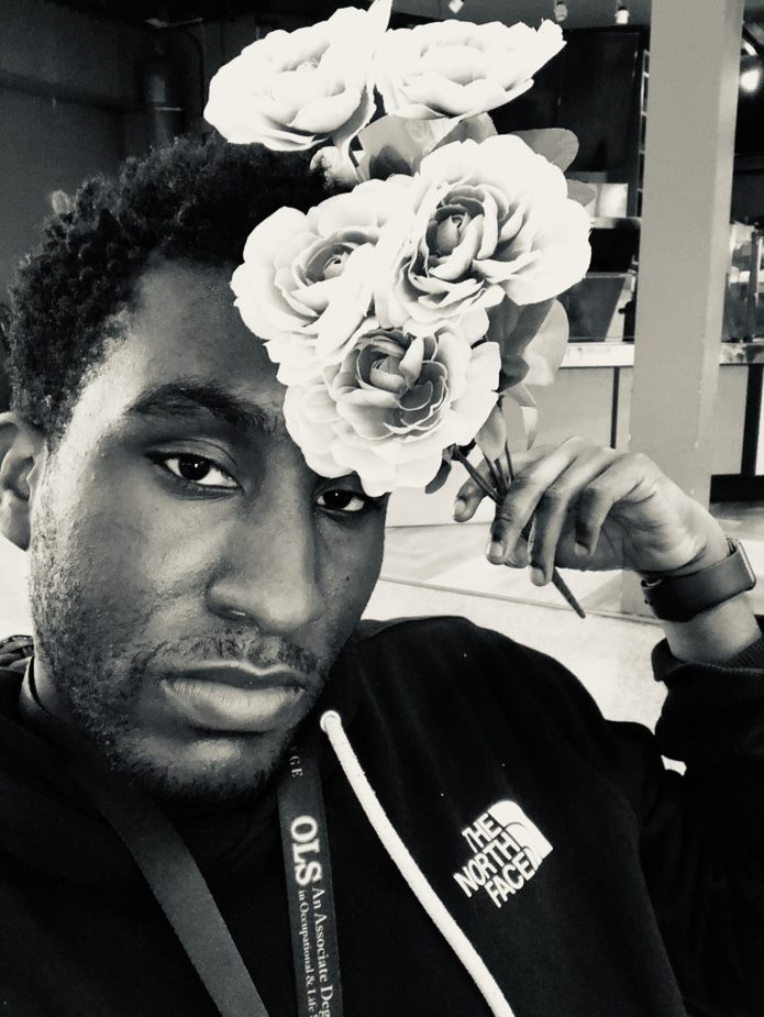 portrait of a young man posing with flowers