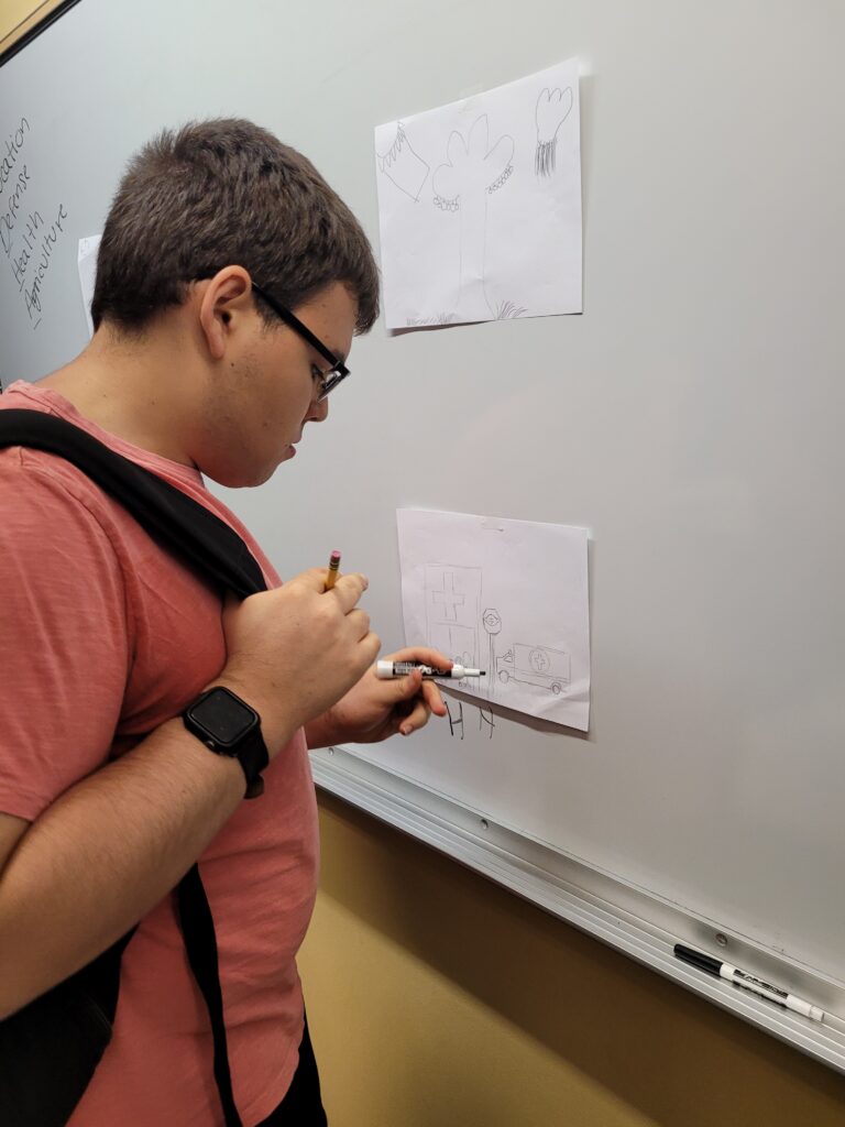 An OLS student works at the whiteboard in class