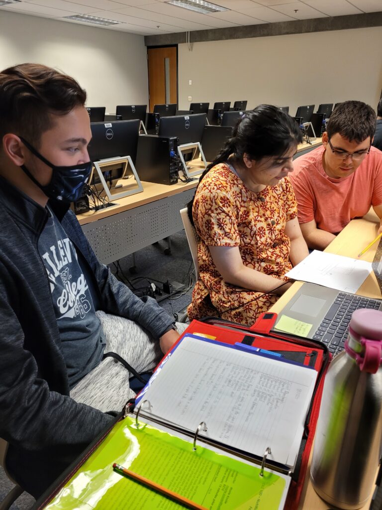 three OLS students working as a group in class