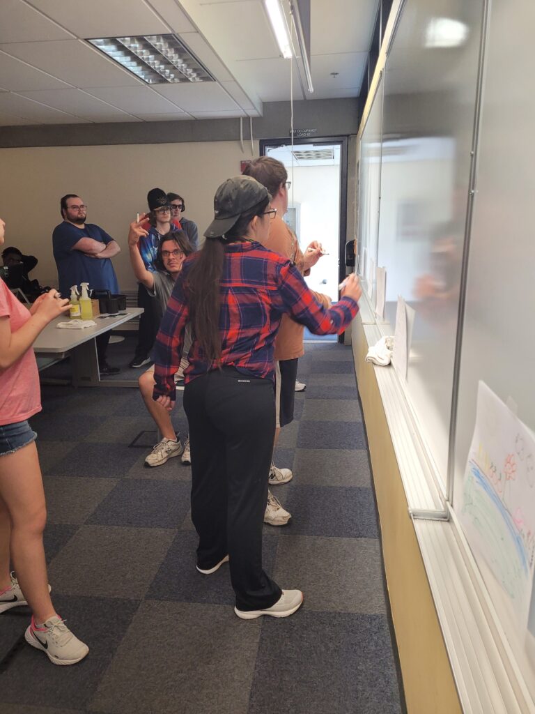 group of OLS students working at the whiteboard in class