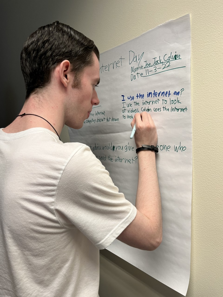 OLS student writes on poster about internet safety