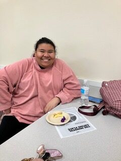 OLS student in class with small pate of food