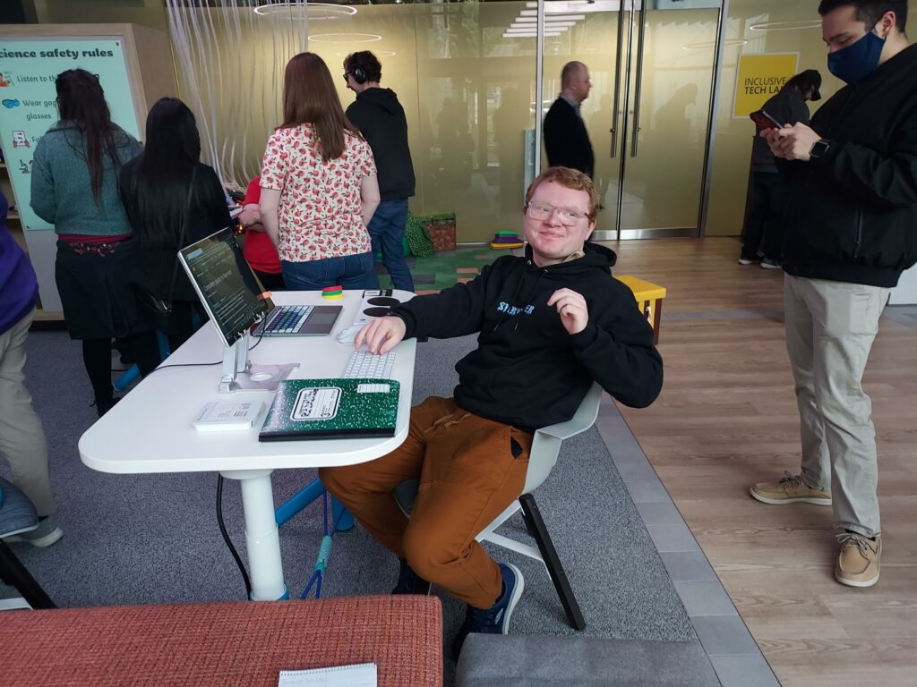 An OLS student sites at a desk with a computer