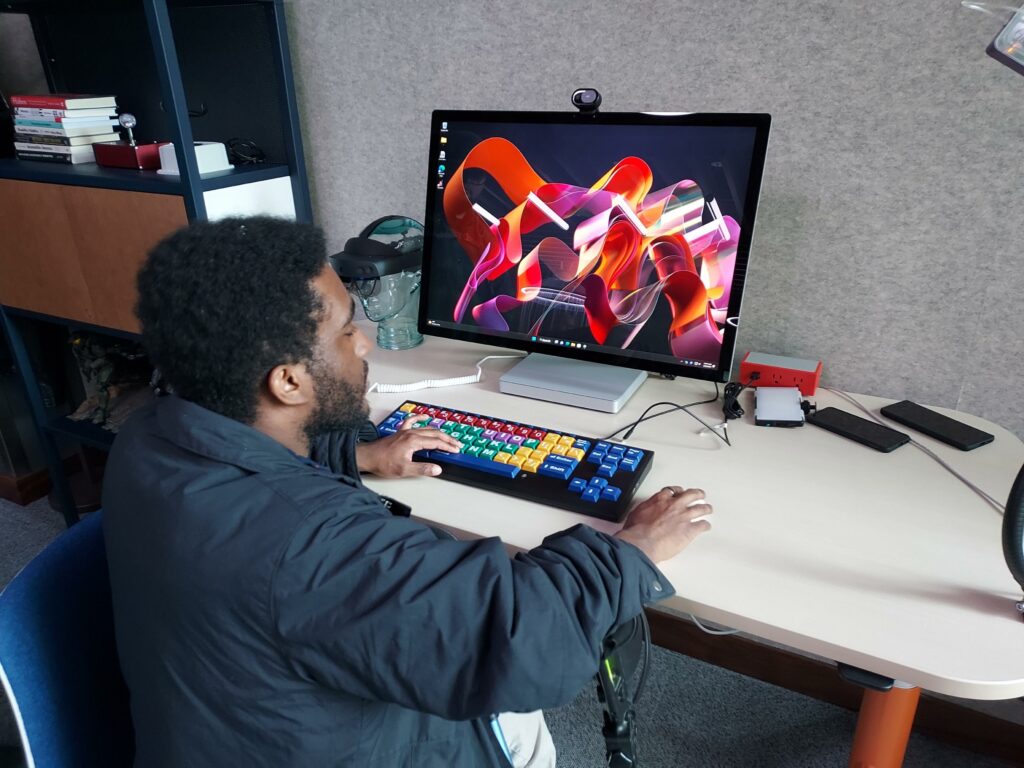 An OLS student checks out a computer with a colorful keypad