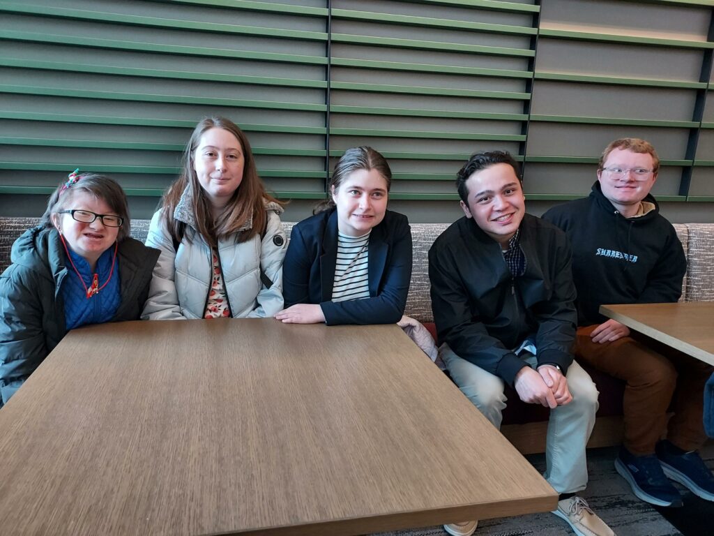 A group of OLS students pose for a photo sitting at a table