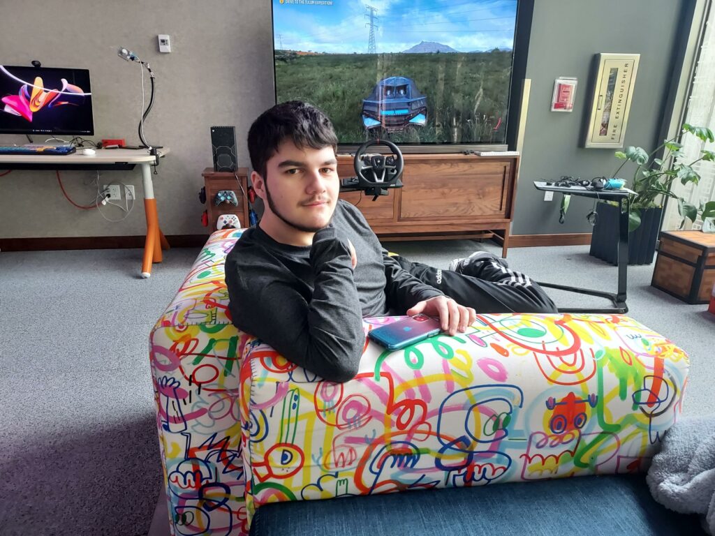 An OLS student sits on a colorful couch