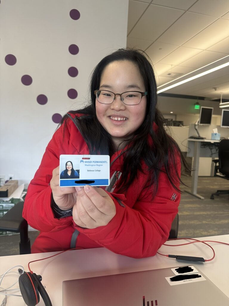 OLSBC student Panida holds up her employee badge at her Kaiser Permanente internship.