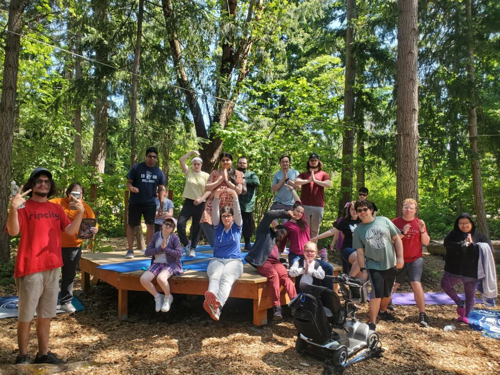 A group of OLS Bellevue College students practice Yoga in a forested area.