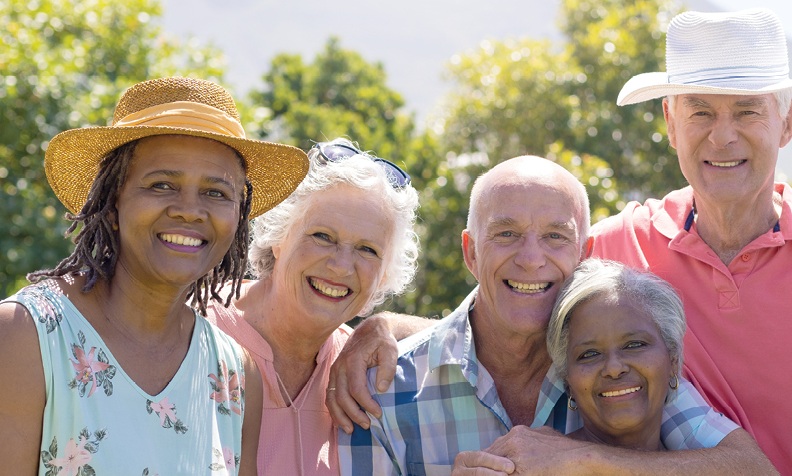 group of diverse seniors smiling outside in the sunshine