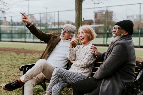 Group of mature adults on a park bench laughing