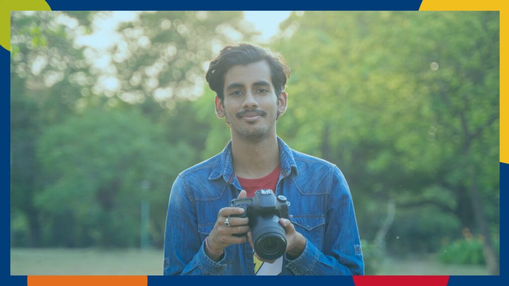 A smiling student with camera