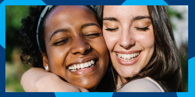 Two student hugging and smiling