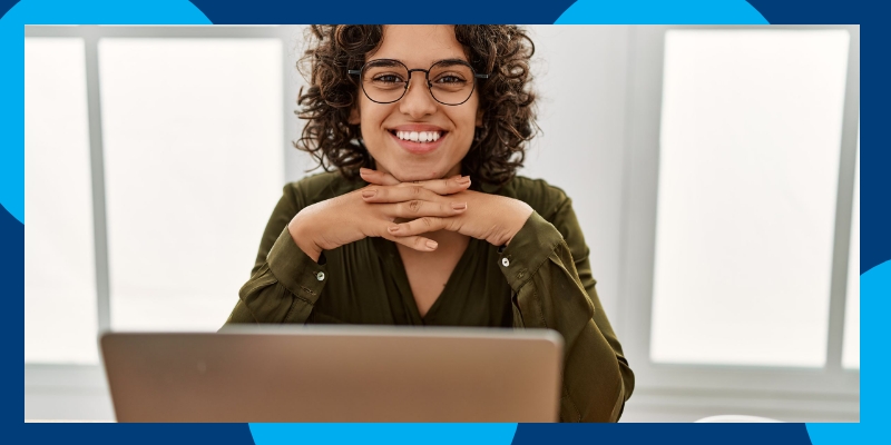 A woman smiling over her laptop