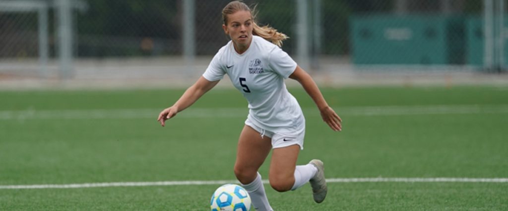 A BC woman's soccer player dribbles the ball