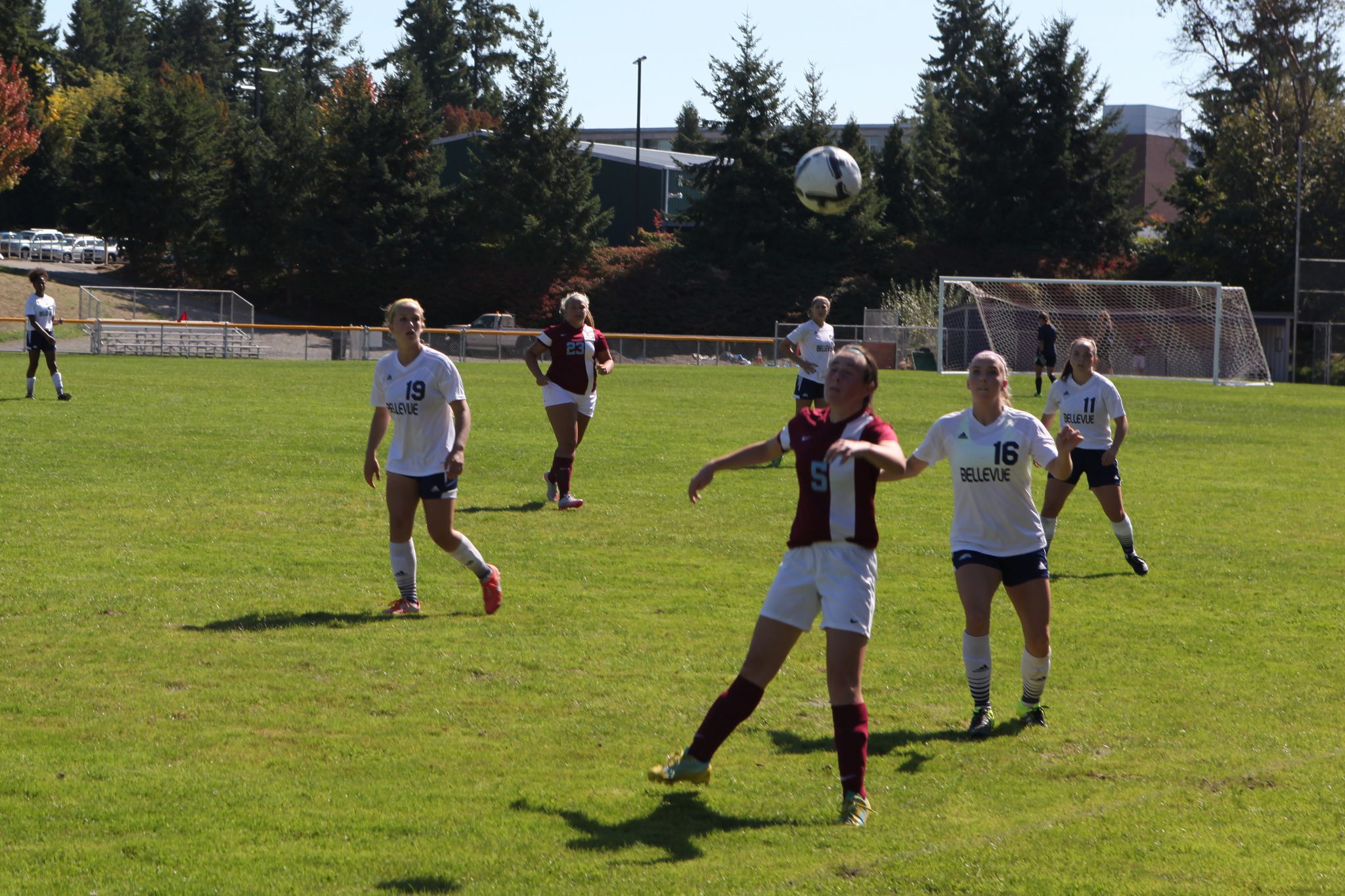Image of Belleve College players converging on a Pierce College player in a women's soccer match