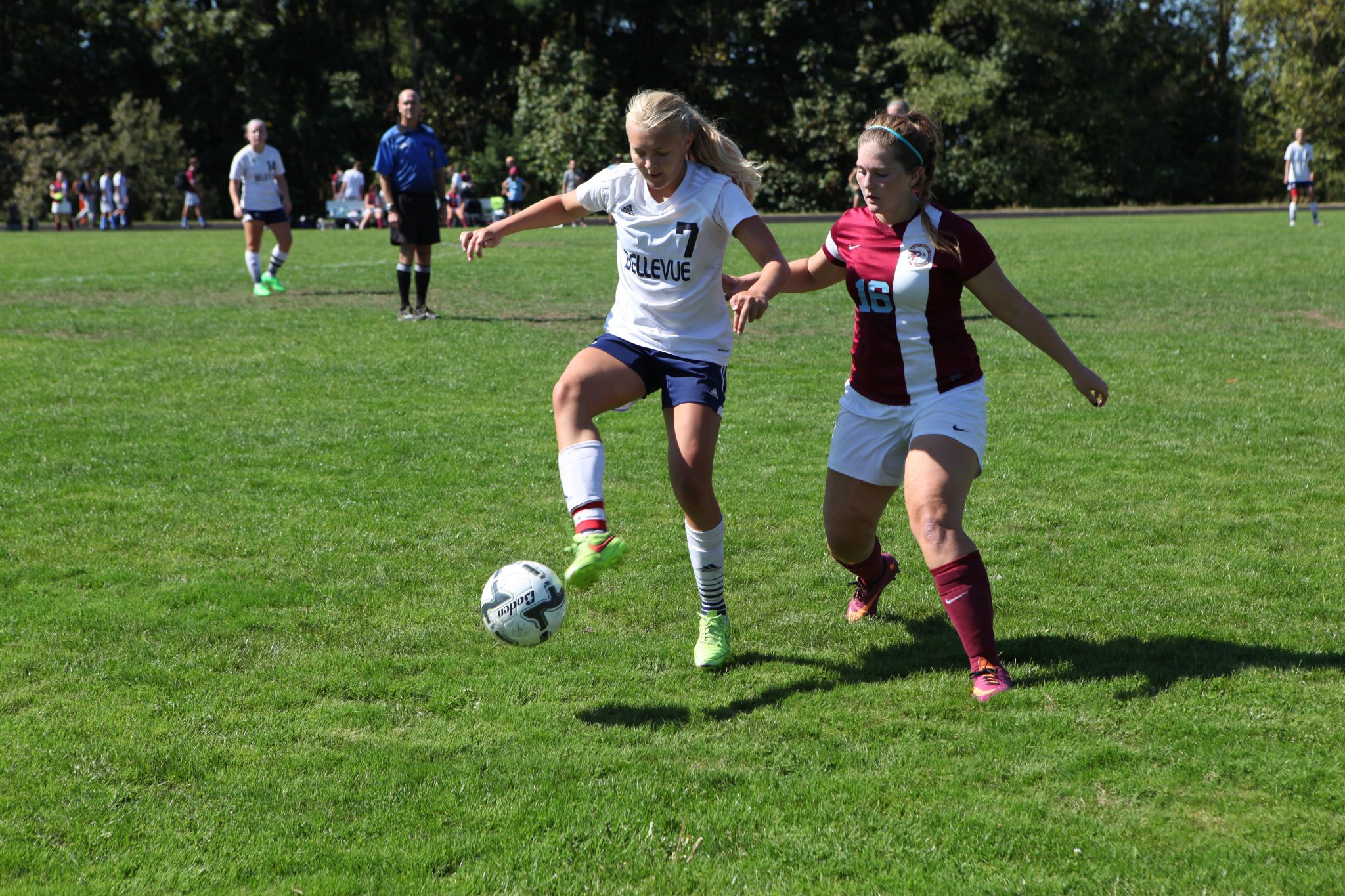 Image of a Bellevue College women's soccer player controlling the ball against a Pierce College defender