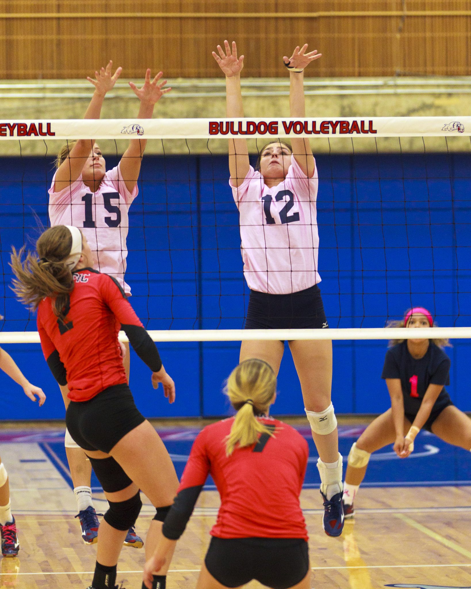 Bellevue College volleyball players go up for the block