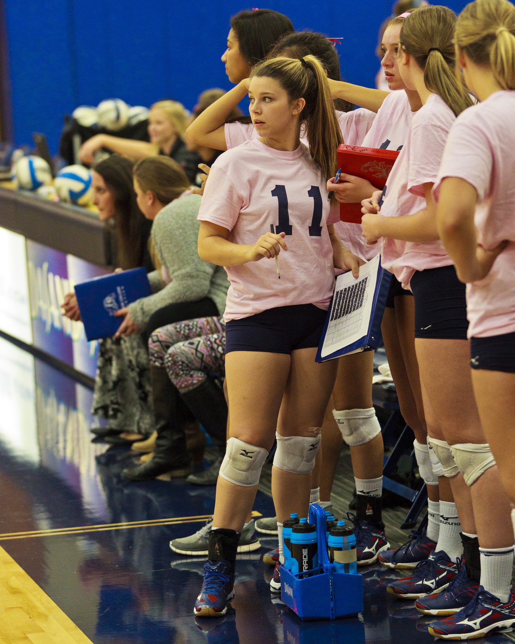 A Bellevue College volleyball player watches the action from the sideline