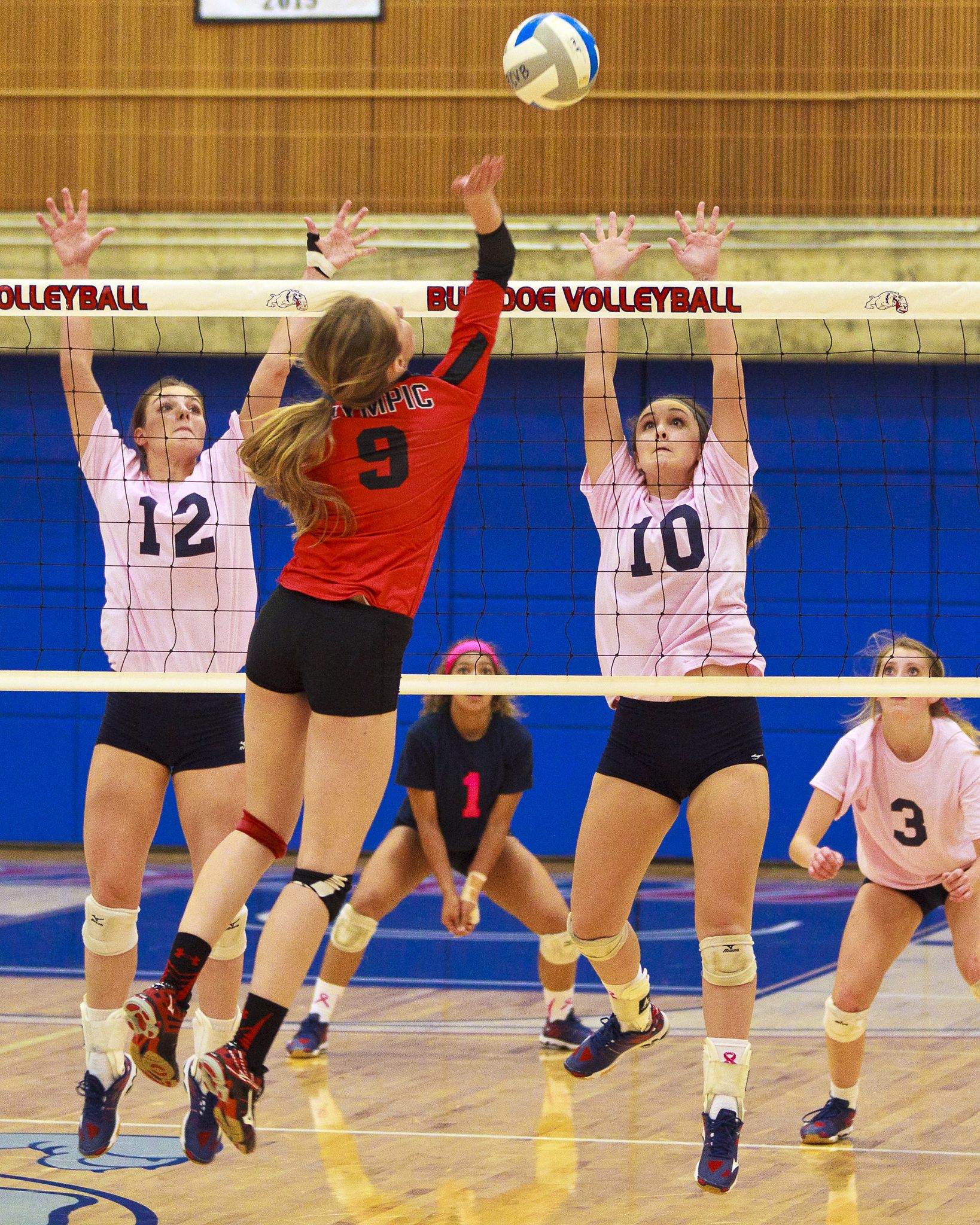 Bellevue College volleyball players go up for the block