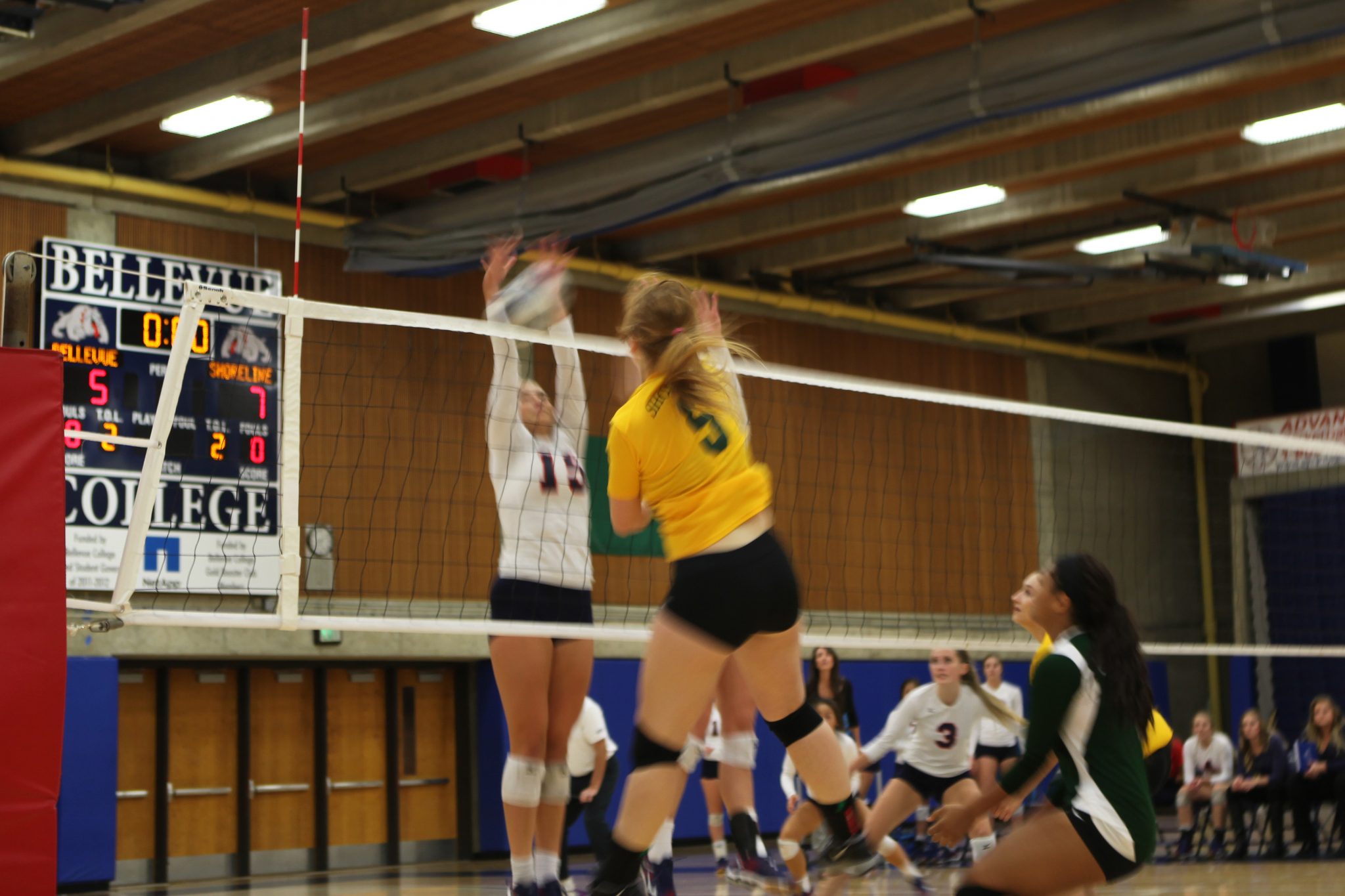 Makenna Martyn of Bellevue College goes for a block against Shoreline