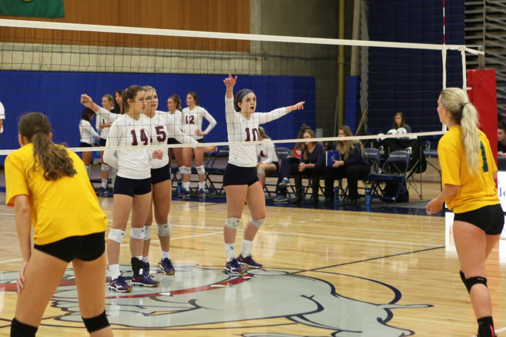 Bellevue College players Briar Perez (14), Makenna Martyn (15) and Sarah Harkleroad (10) get ready to receive a serve against Shoreline