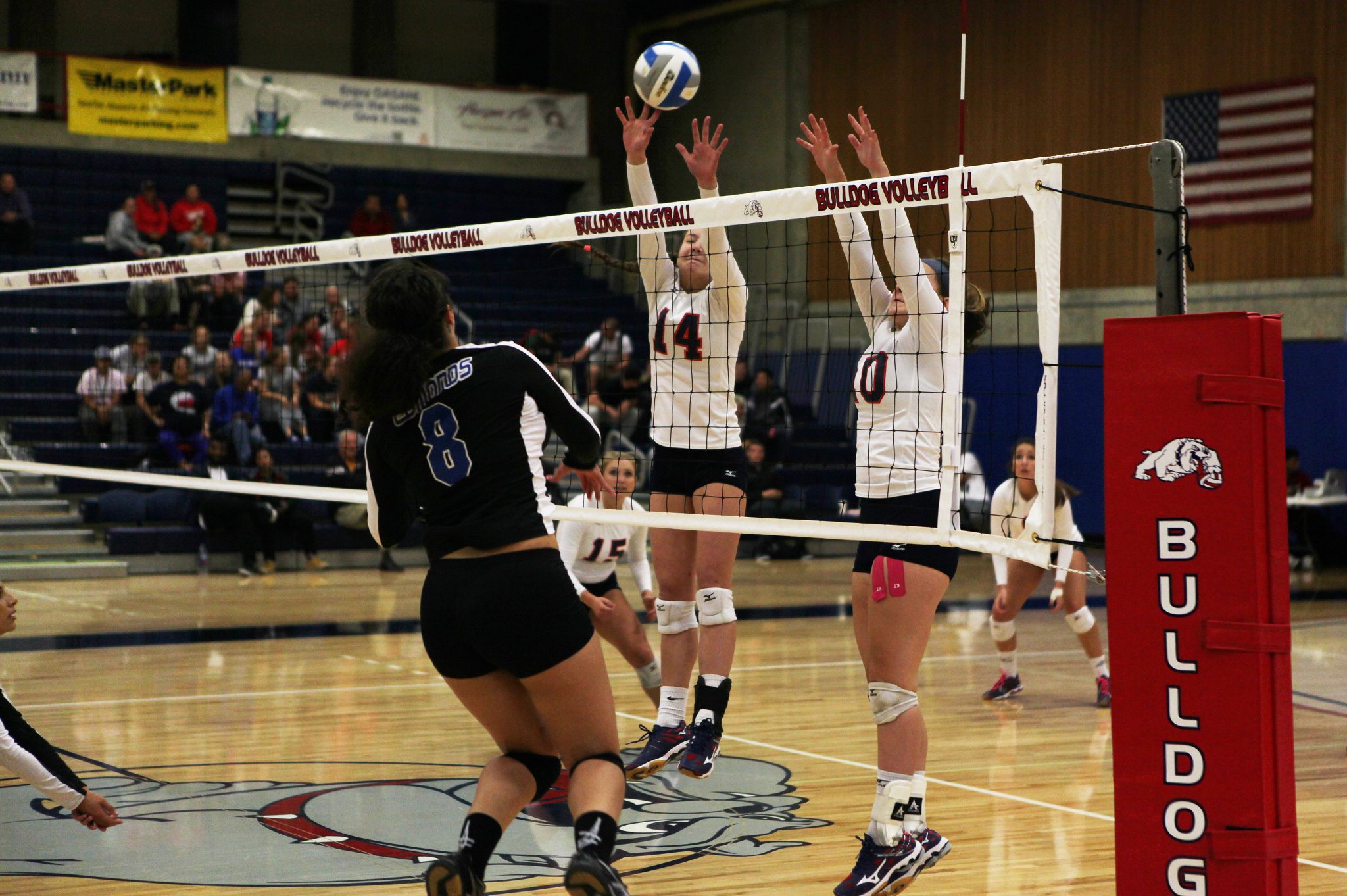 Two Bellevue College players go up for a block against Edmonds