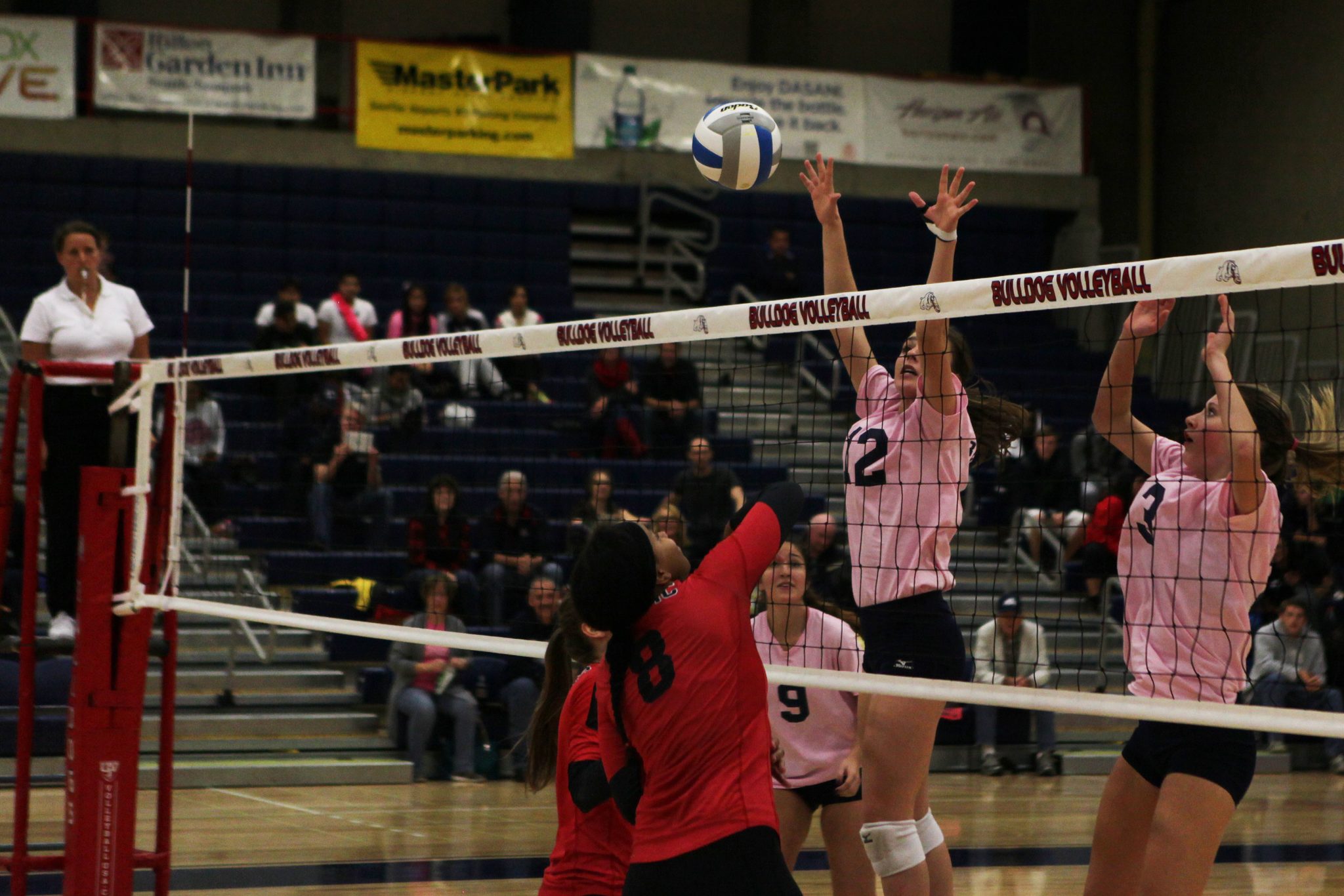Bellevue College players go up for a block in a volleyball match against Olympic