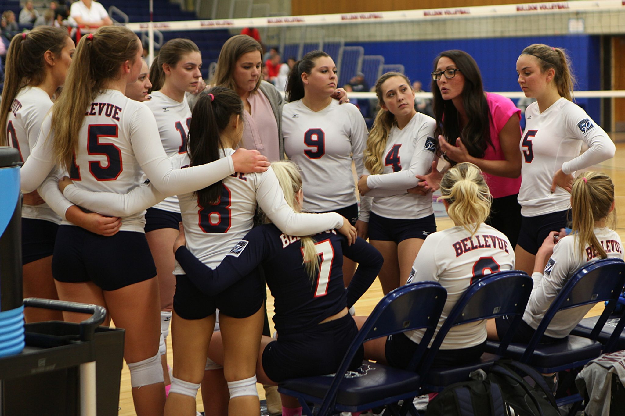 BC volleyball players gather around coach Jocelyn Lawrence in front of the bench