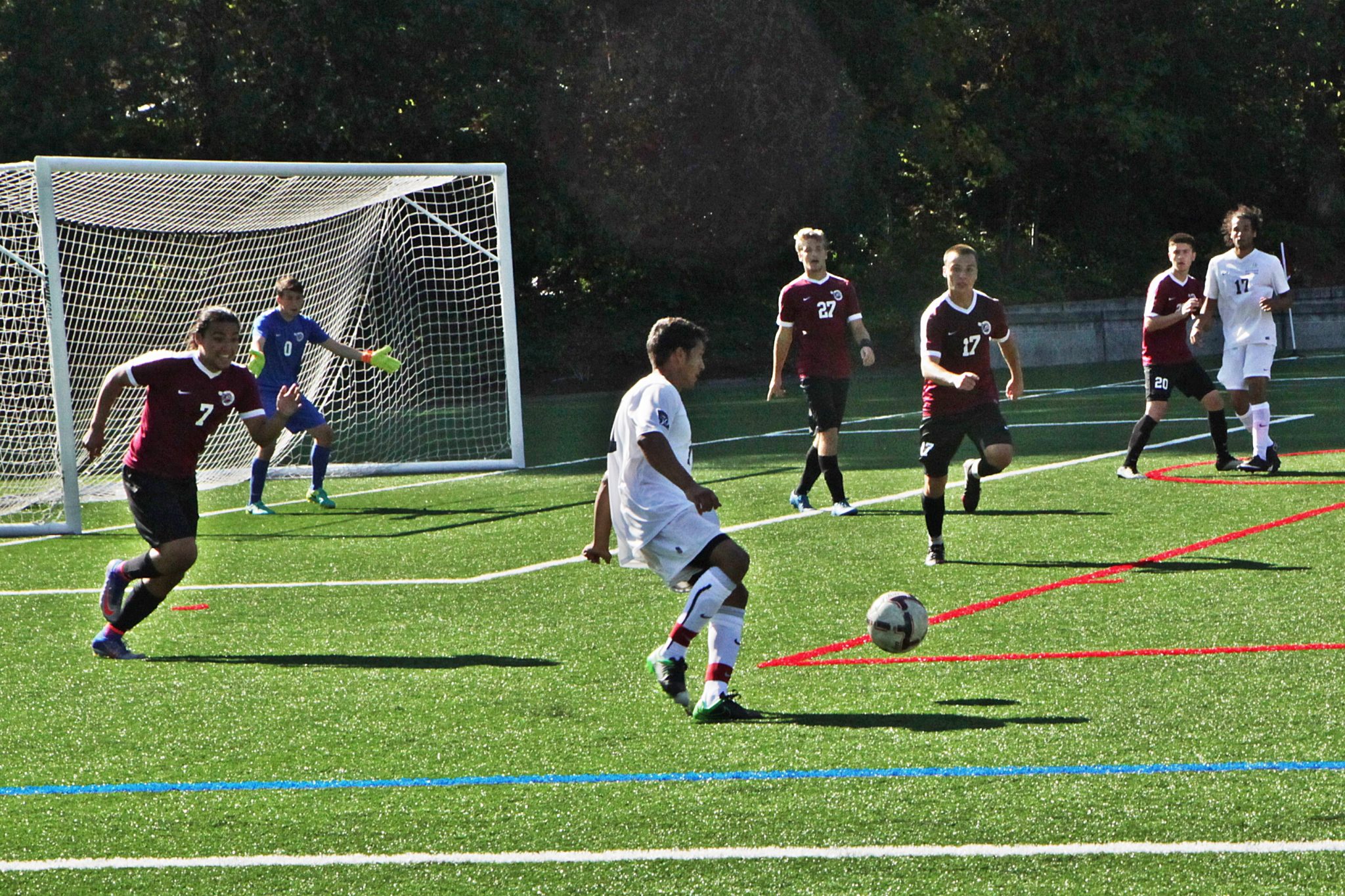 A BC men's soccer player kicks the ball against Pierce