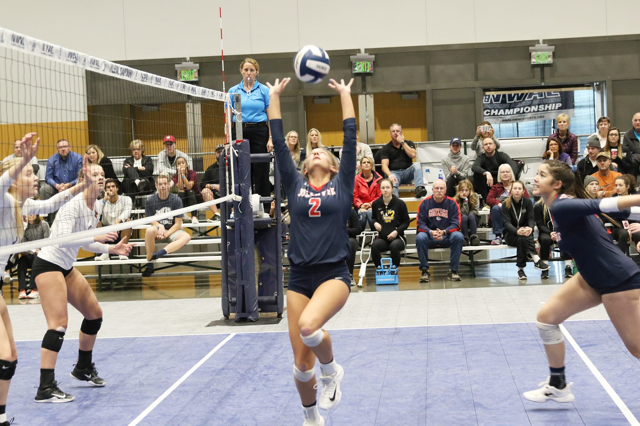 A BC player sets the ball at the net