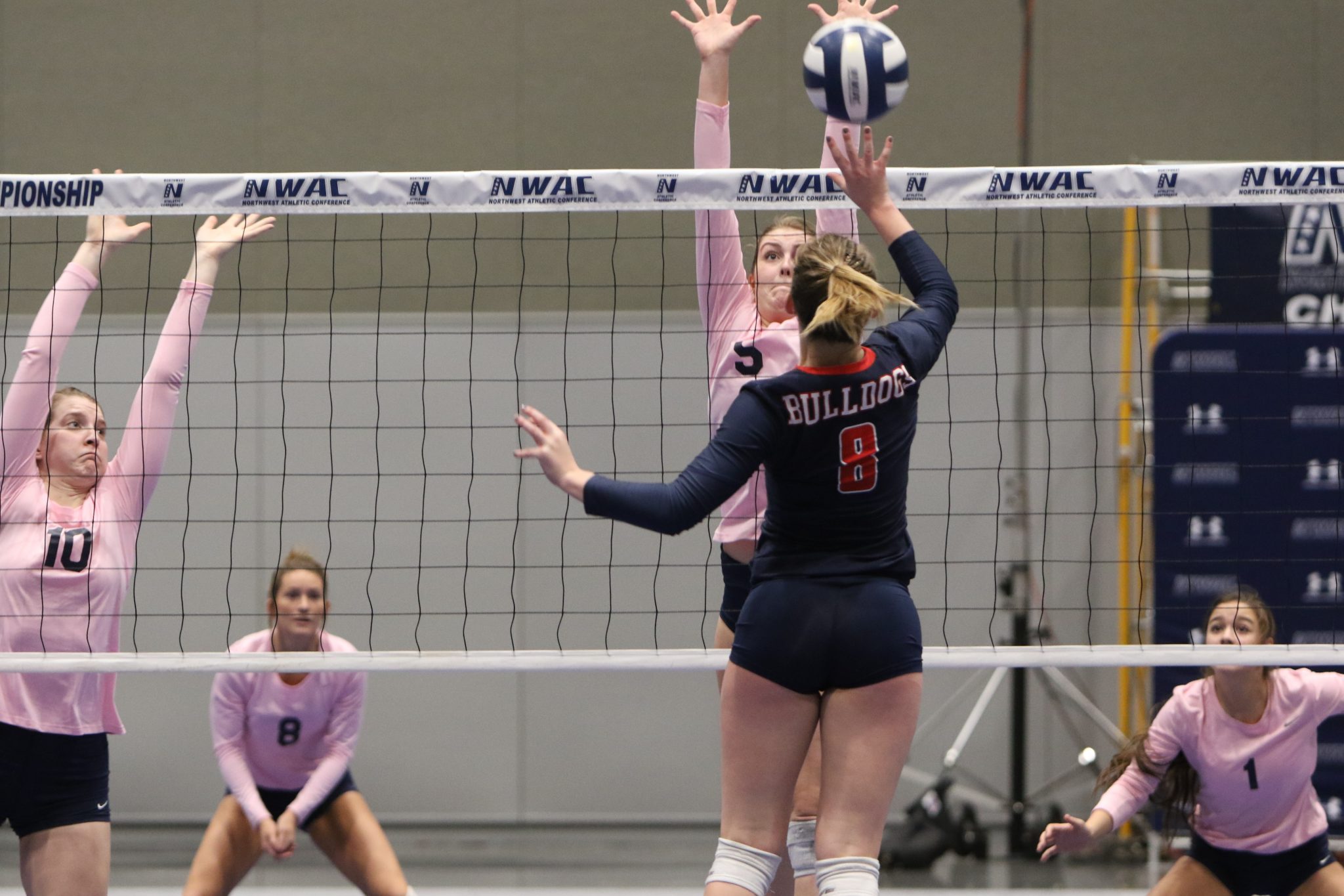 A BC player taps the ball over the net