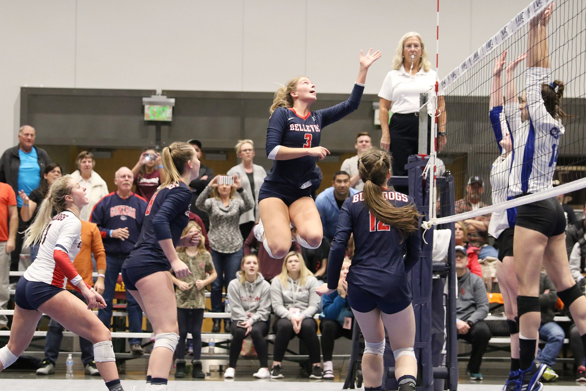 A BC player soars above the net after a shot