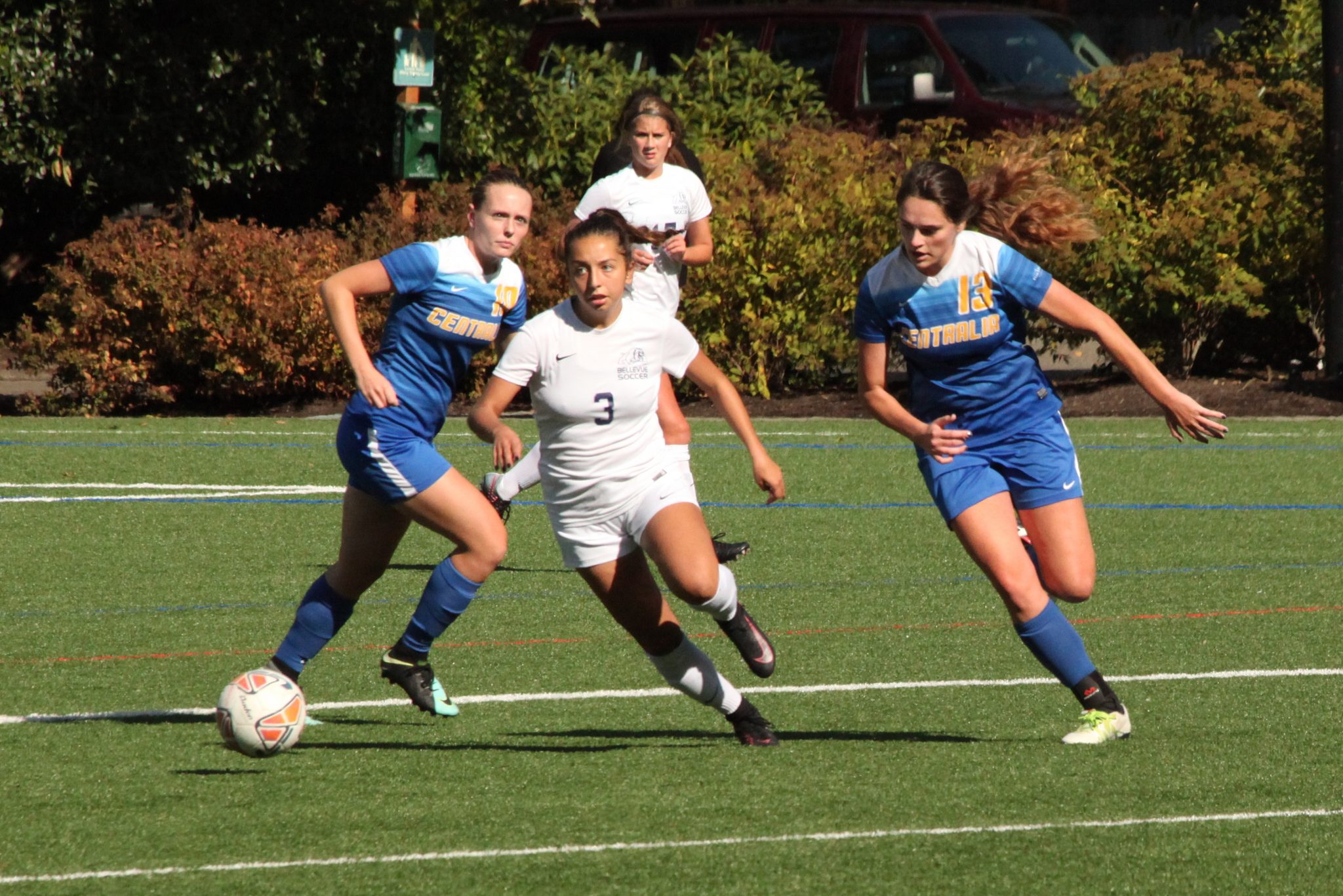 A BC player pursues the ball between two defenders