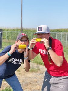 BC coach Leah Francis and a player eating corn on the cob